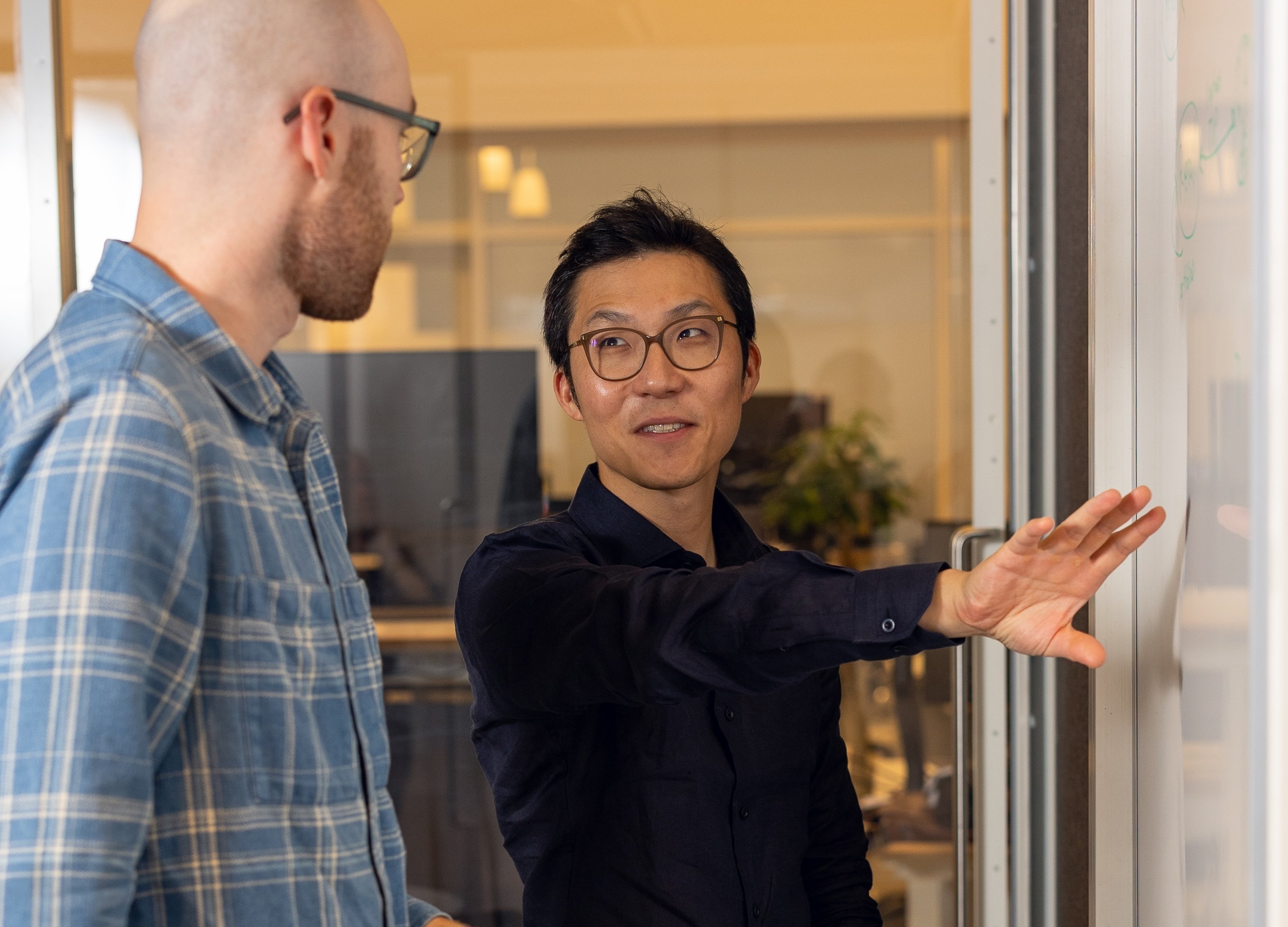 A photograph of two Betterment Investing team members at a white board.